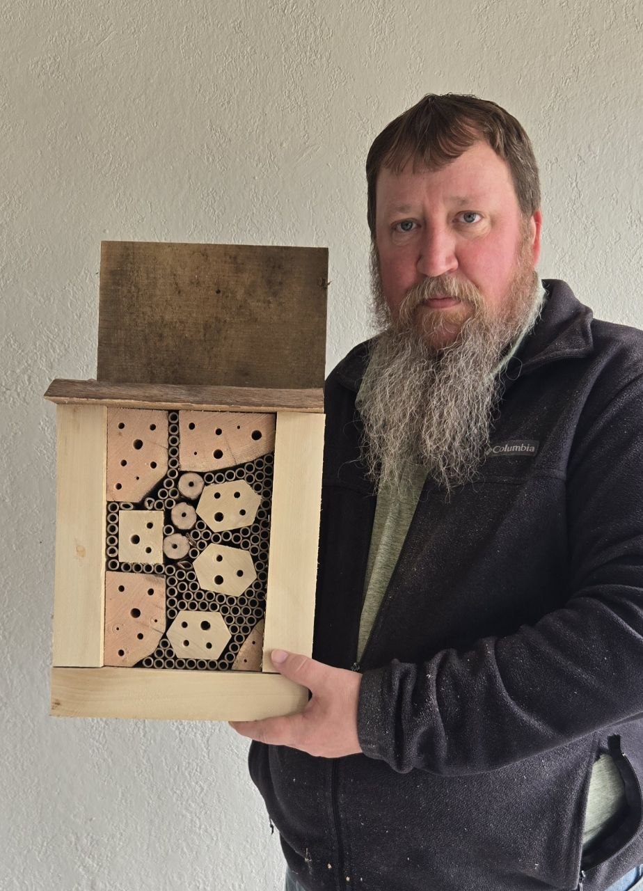 Finished rustic backyard bee hotel held up for scale