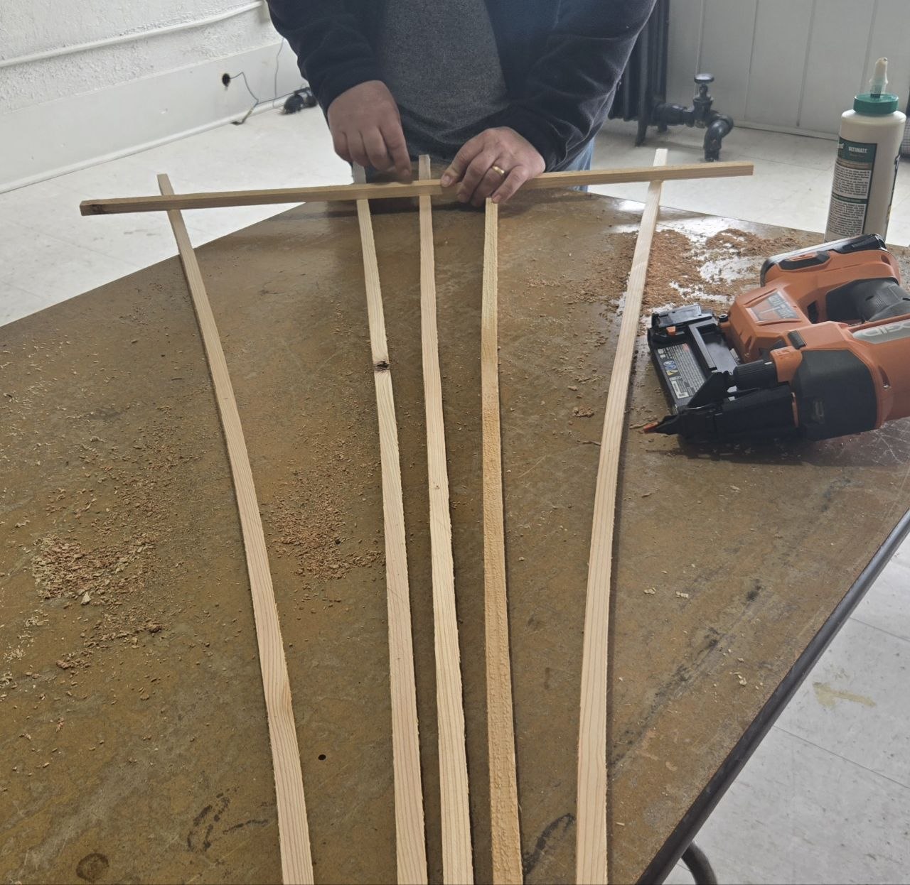 Placing and pin nailing the 3 foot spreader across the top of the fan trellis