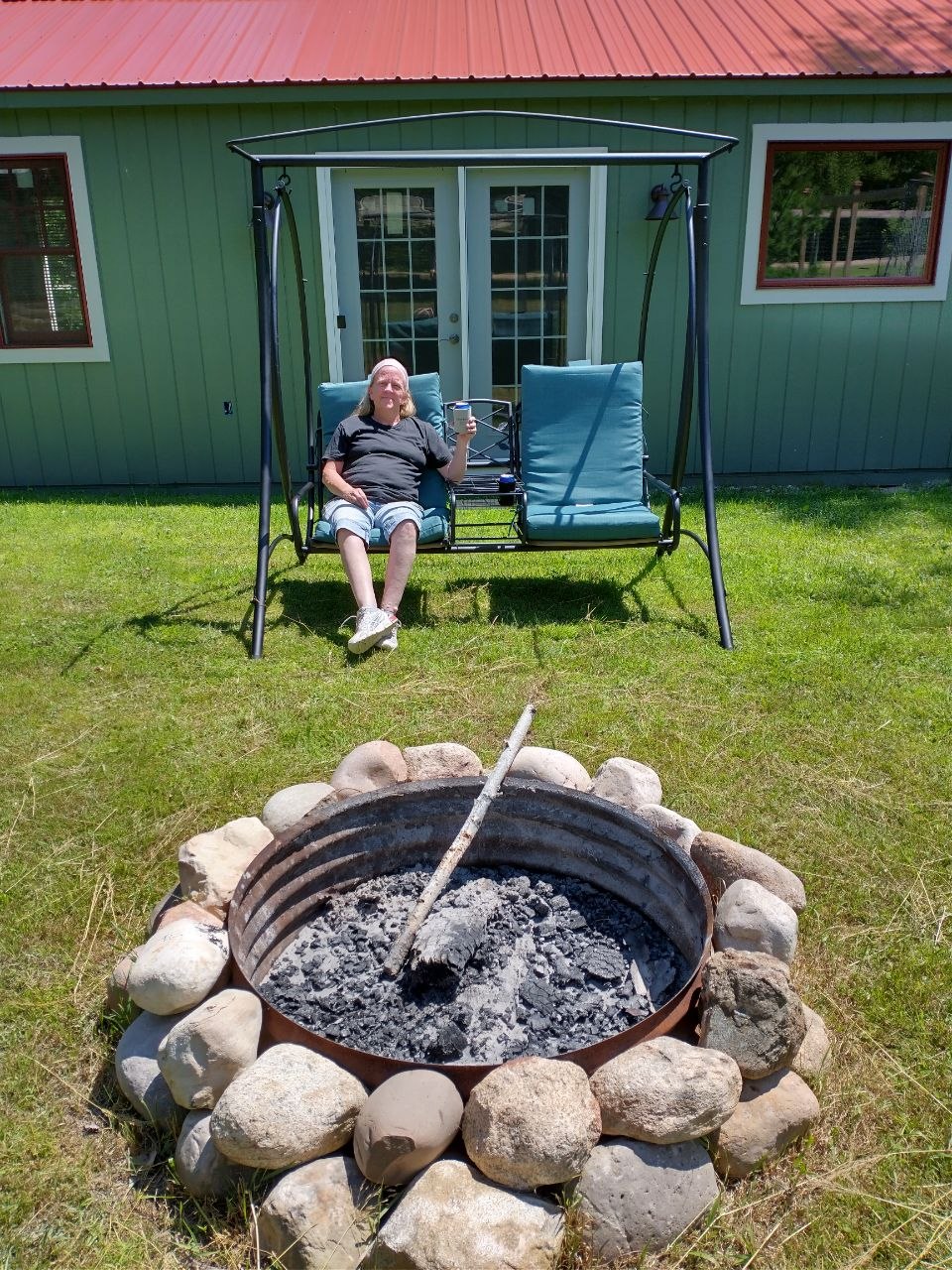 Vanessa relaxing on the swing by the fire ring during the early peaceful cabin days
