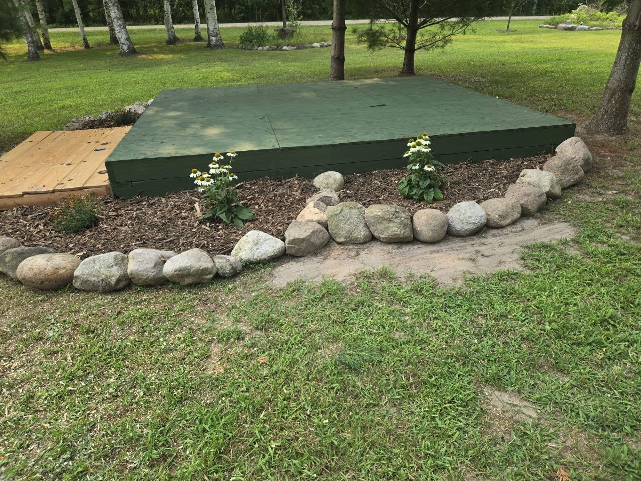 Rock edging and herb/perennial bed area starting to take shape around the saved structure