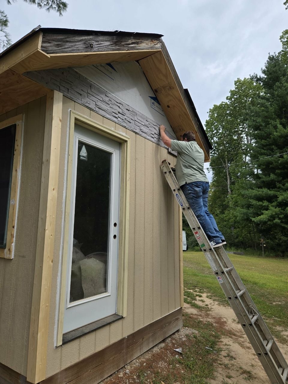 Jeff working on the siding and trim as the structure moves from emergency save toward real restoration