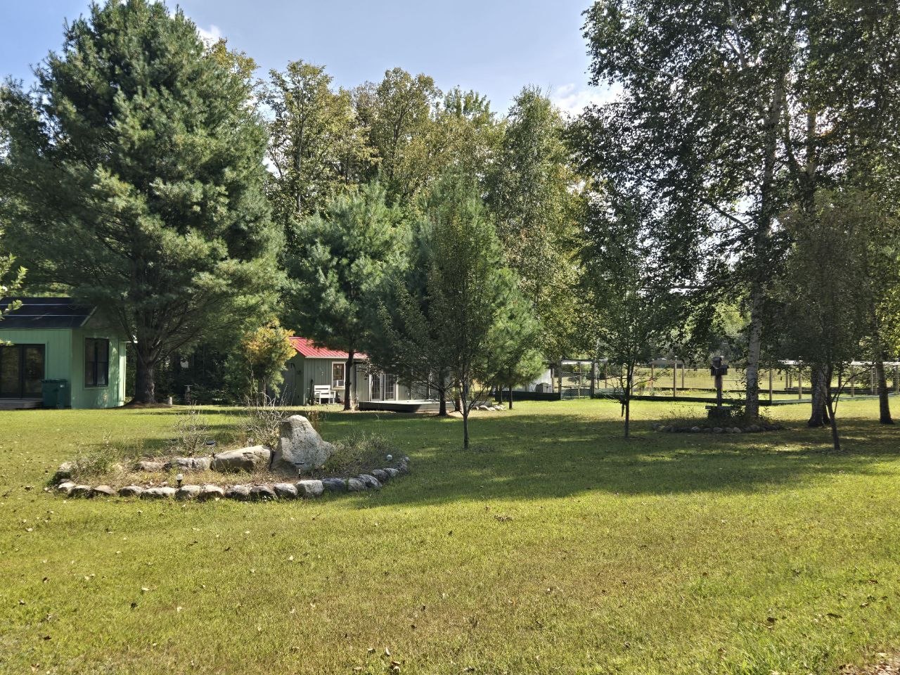 Wide view of the cabin, deck, and yard after years of work and change