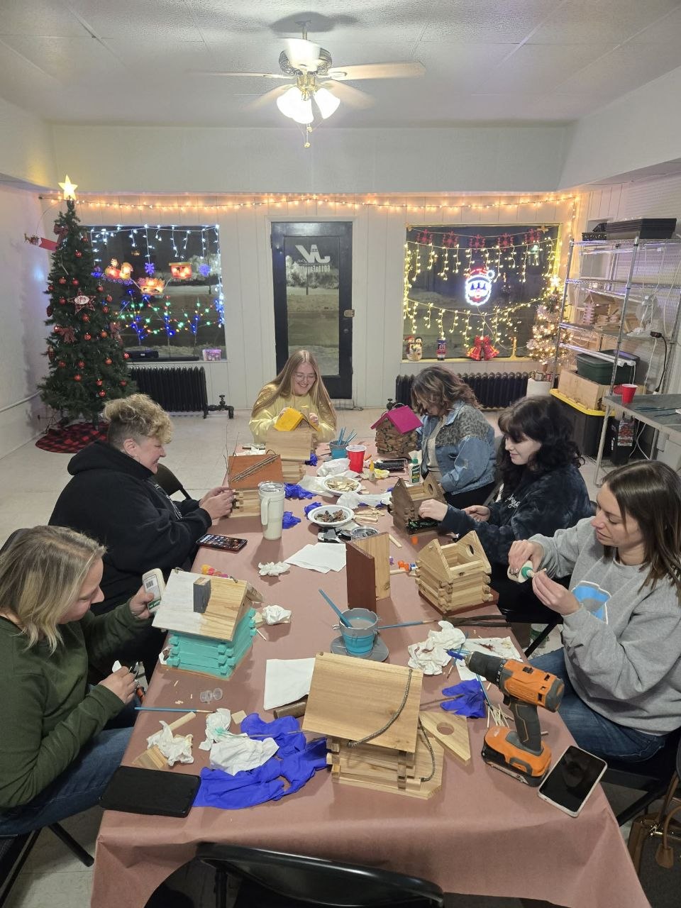 Vanessa's Christmas Sip and Build party with friends making and decorating birdhouses