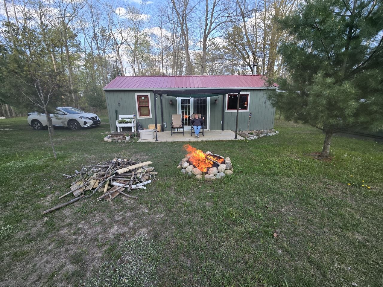 Daytime bonfire in front of the cabin during spring cleanup and reopening work in 2026