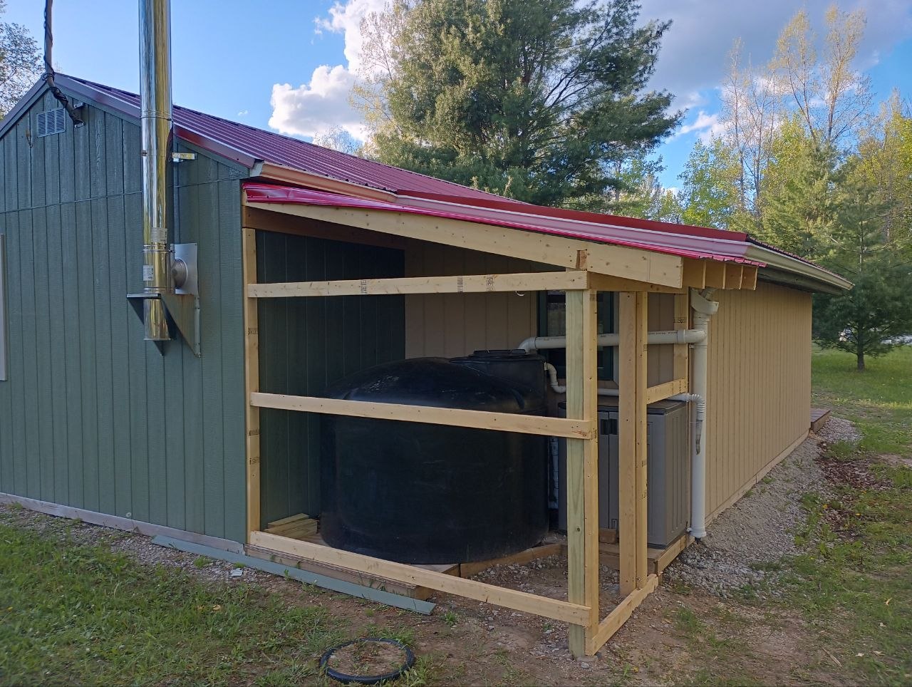 Framed enclosure built around the water tank and utility area at the cabin