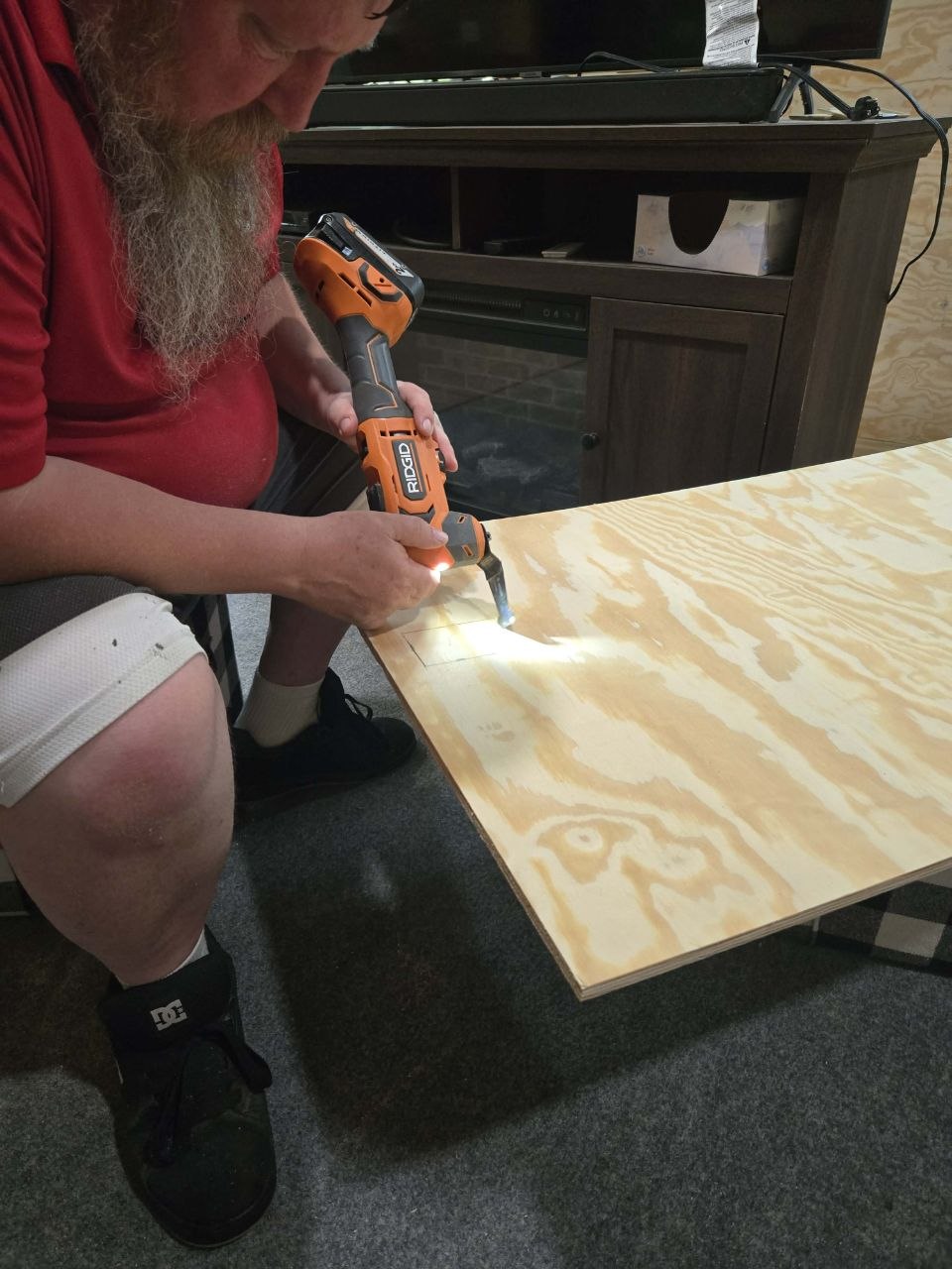 Cutting plywood pieces in the storage shed during the June 2026 cabin wall project