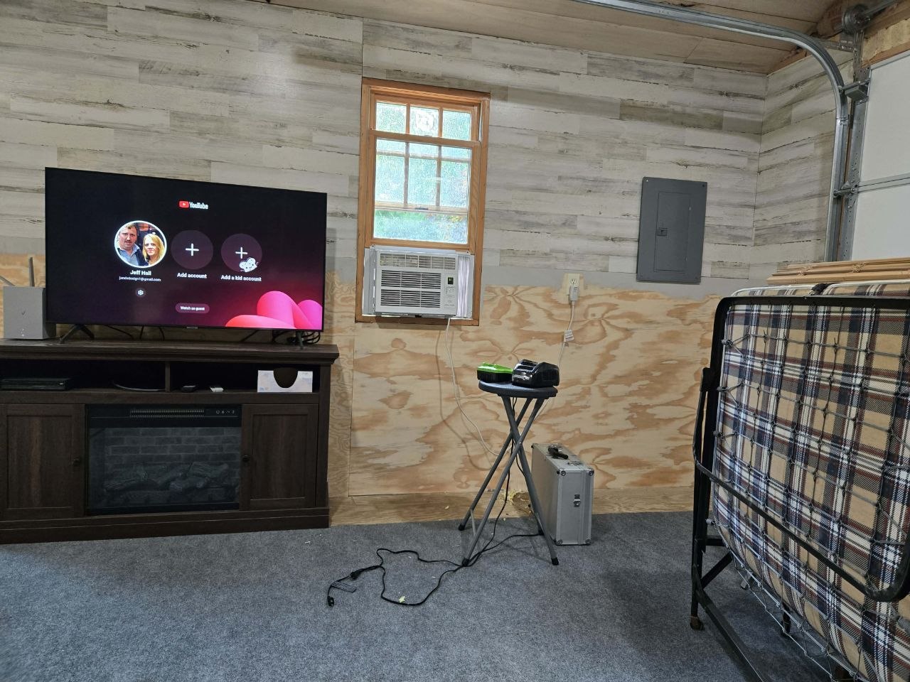 Partially finished cabin wall with decorative paneling and plywood while the project started fighting back in June 2026
