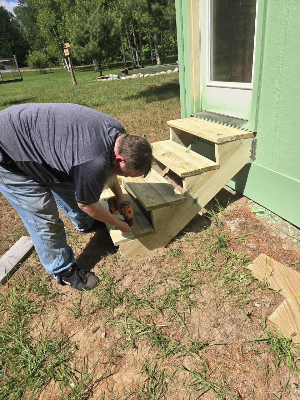 Beginning to build simple wooden steps for the green storage shed at the cabin in June 2026